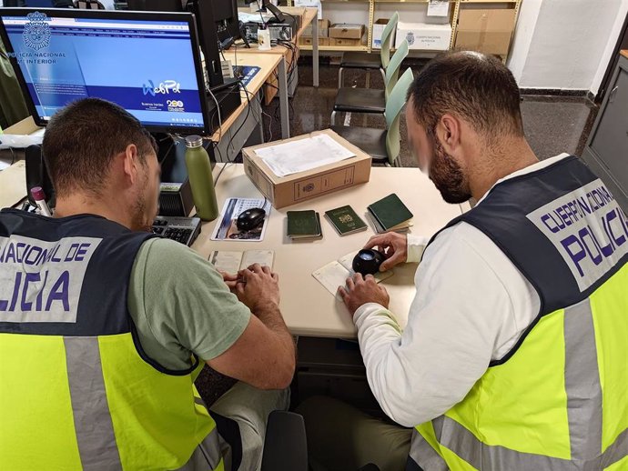 Agentes de la Policía Nacional con los pasaportes intervenidos.