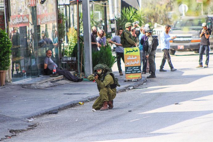 November 2, 2023, Nablus, West bank, Palestine: An Israeli soldier seen aiming while guarding Jewish settlers who launched an attack on the Palestinian town of Deir Sharaf following a shooting attack that killed an Israeli near the area, in the town of 