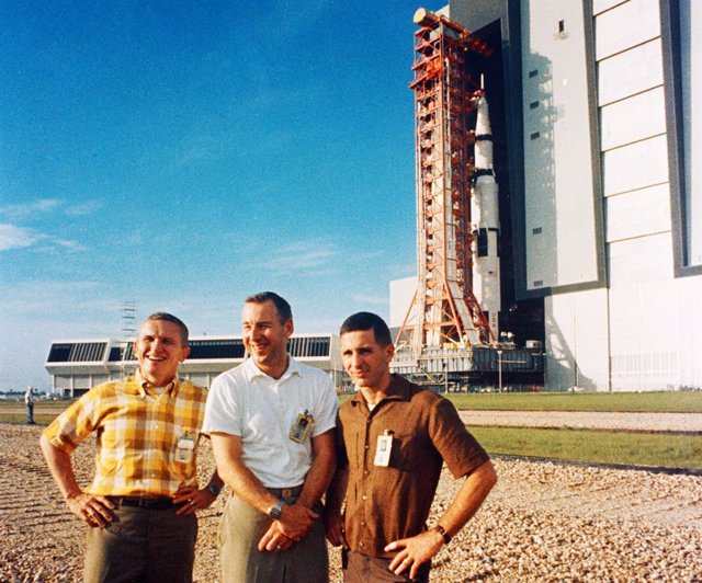 October 9, 1968 - Cape Canaveral, Florida, U.S. - The Apollo 8 crew stands in foreground as their Saturn V launch vehicle rolls out of the Vehicle Assembly Building at NASA's Kennedy Space Center on Oct. 9, 1968. The Apollo 8 crew consists of, from the le