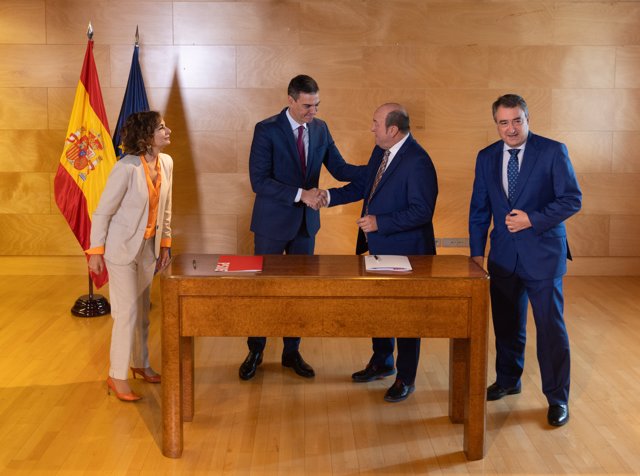 El presidente del Gobierno en funciones y candidato a la reelección, Pedro Sánchez (i), y el presidente del EBB del PNV, Andoni Ortuzar (d), firman un acuerdo para la investidura. 
