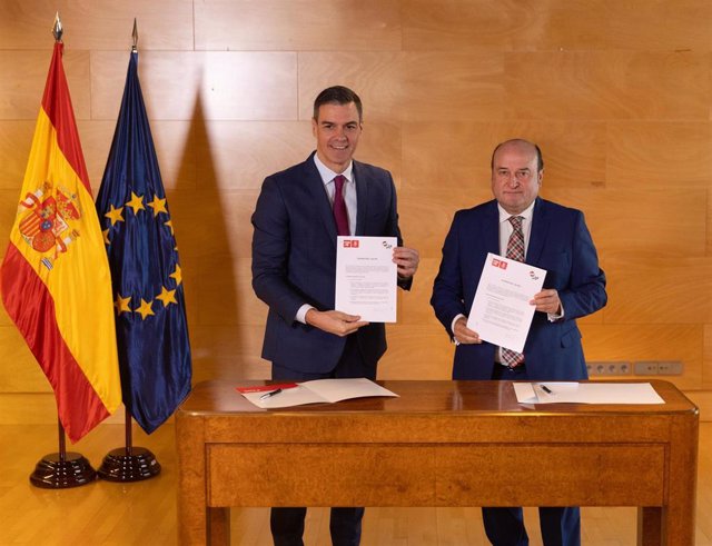 El presidente del Gobierno en funciones y candidato a la reelección, Pedro Sánchez (i), y el presidente del EBB del PNV, Andoni Ortuzar (d), firman un acuerdo para la investidura, en el Congreso de los Diputados