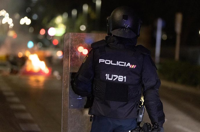 Un Policía sujeta un escudo observando la barricada de los manifestantes concentrados en la sede del PSOE en la calle Ferraz de Madrid, a 7 de noviembre de 2023, en Madrid (España). 