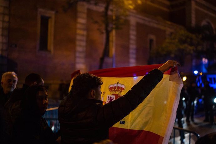 Un manifestante sostiene una bandera española durante la concentración en contra de la amnistía, en la sede del PSOE en la calle Ferraz, a 8 de noviembre de 2023, en Madrid (España)