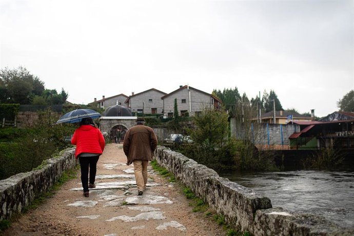 Varias personas cruzan un puente observando la crecida del río Tea, a 4 de noviembre de 2023, en Ponteareas, Pontevedra, Galicia (España). 