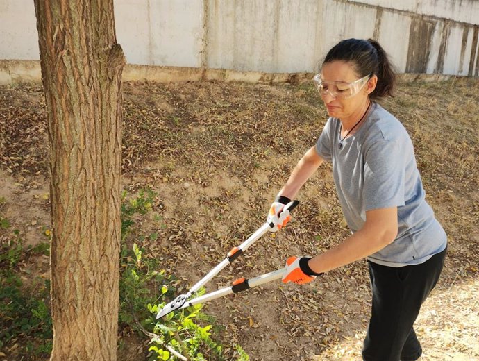 Una mujer realiza labores de poda