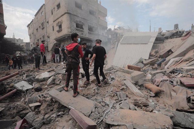 Palestinos junto a edificios destruidos por los ataques en Bureij, en la Franja de Gaza