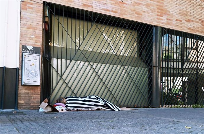 Archivo - Un persona sin hogar en la céntrica Plaza del Cristo de Burgos.