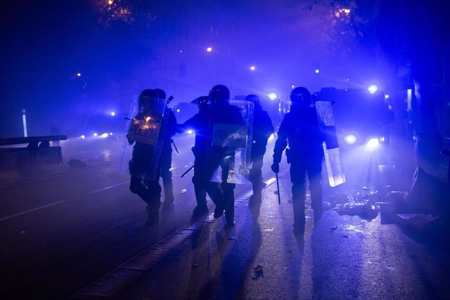 Varios agentes se disponen a cargar contra un grupo de manifestantes durante una protesta contra la amnistía, frente a la sede del PSOE