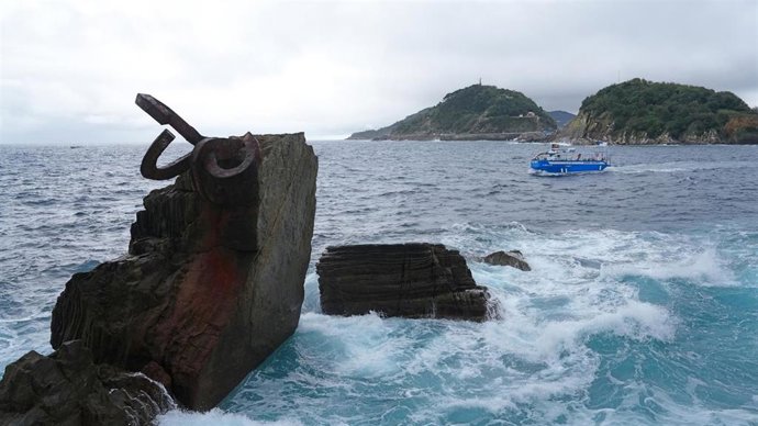 Archivo - Una embarcación pasa cerca del Peine del Viento, en San Sebastián