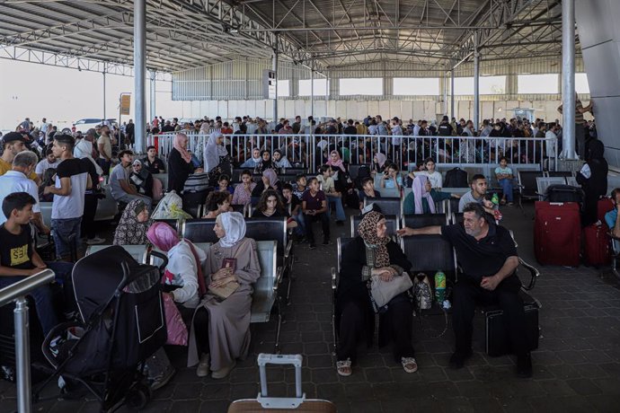 Un grupo de personas espera para salir de la Franja de Gaza a través del paso de Rafá, en la frontera con Egipto