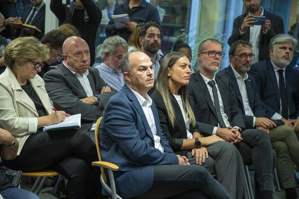 El secretario general de Junts per Catalunya, Jordi Turull (5d), y la diputada de Junts, Miriam Nogueras (4d), durante la rueda de prensa del expresidente de la Generalitat y eurodiputado de Junts, Carles Puigdemont para explicar los detalles del acuerd