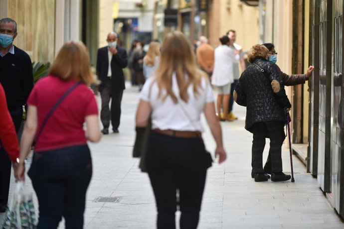 Archivo - Varias personas caminan por una céntrica calle de Murcia.
