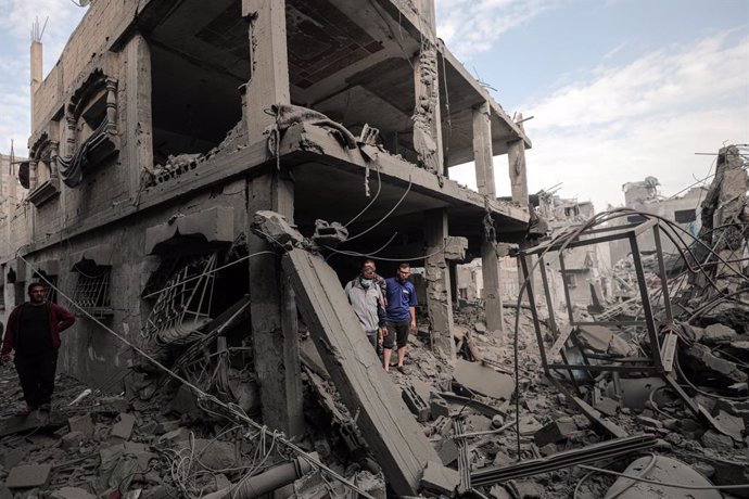 GAZA, Nov. 13, 2023  -- People are seen among the rubble of buildings destroyed in an Israeli bombing at Bureij refugee camp in central Gaza Strip, on Nov. 13, 2023. The government media office in Gaza announced on Monday that the Palestinian death toll