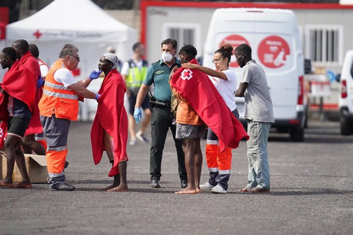 Trabajadores de la Cruz Roja tapan con mantas a los más de 170 migrantes que han llegado al Puerto de la Restinga de la isla de El Hierro, a 31 de octubre de 2023, en El Hierro, Santa Cruz de Tenerife, Tenerife, Canarias (España). Un nuevo cayuco ha lle