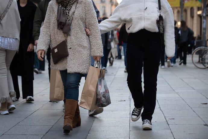 Archivo - Varias personas realizan compras en la avenida de la Puerta del Ángel de Barcelona.