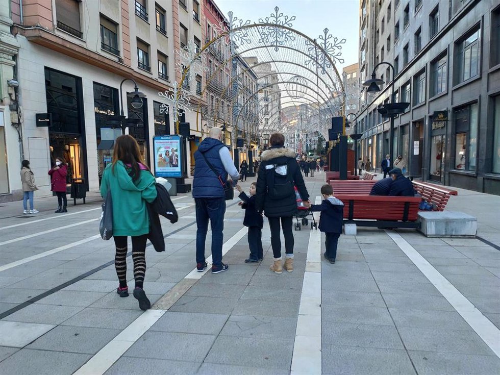 Archivo - Una familia con niños pasea por las calles de Oviedo durante la Navidad de 2021.