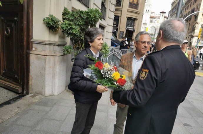 La presidenta de Societat Civil Catalana (SCC), Elda Mata, y el responsable de Territoriales de la entidad, Jorge Fernández-Argüelles, entregando flores en la Jefatura Superior de Policía de Catalunya