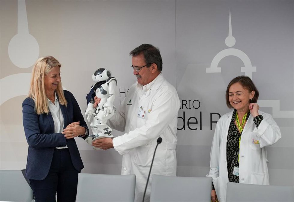 La presidenta de la Asociación ETC, Gloria Álvarez; junto al director gerente del Hospital Virgen del Rocío, Manuel Molina; y directora de la Unidad Pedriátrica, Catalina Márquez, junto al robot.