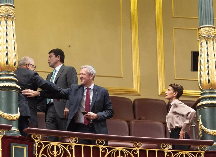 El presidente de la Xunta de Galicia, Alfonso Rueda (2d), y la presidenta del Gobierno de Navarra, María Chivite (1d),  durante la primera sesión del debate de investidura de Pedro Sánchez como presidente de Gobierno, en el Congreso de los Diputados, a 