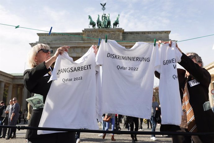 Archivo - 23 October 2022, Berlin: Actors hang T-shirts bearing terms such as press censorship, forced labor, discrimination, trade union bans and judicial arbitrariness on a clothesline in front of the Brandenburg Gate, during an art action by Amnesty 