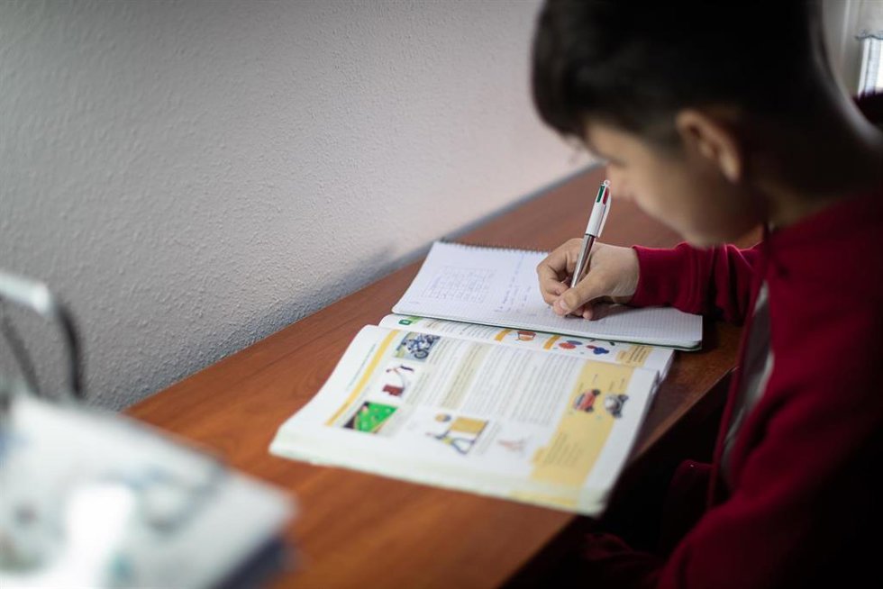 Archivo - Un niño realiza sus deberes en su habitación durante el confinamiento por el estado de alarma, cuando España es el único país que no deja a los menores salir a la calle y un día después de que la ministra de Educación anunciara que el curso es