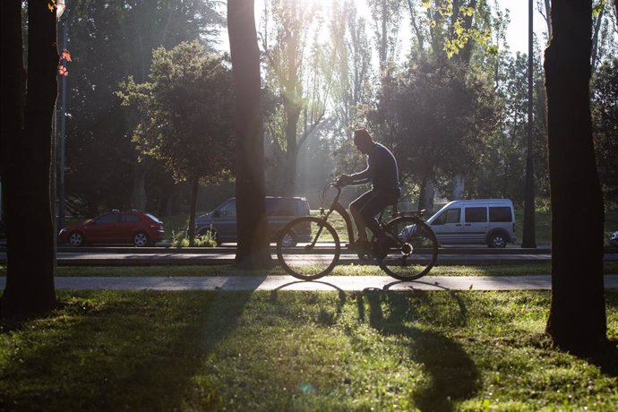 Archivo - Un hombre monta en bicicleta en una jornada soleada en Vitoria