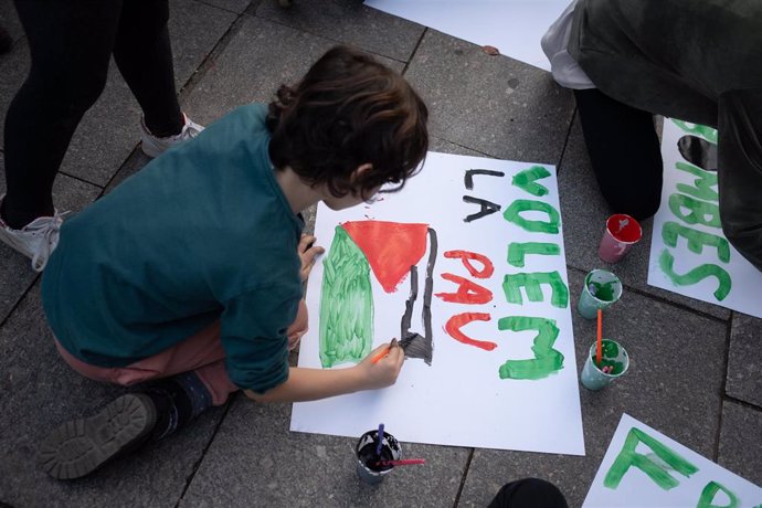 Un niño pinta una pancarta en solidaridad con Palestina en la Escola Rius i Taulet de Barcelona