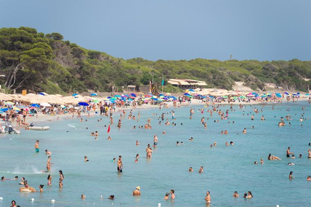 Archivo - Varias personas se bañan en la playa de Ses Salines, a 11 de julio de 2023, en Ibiza.