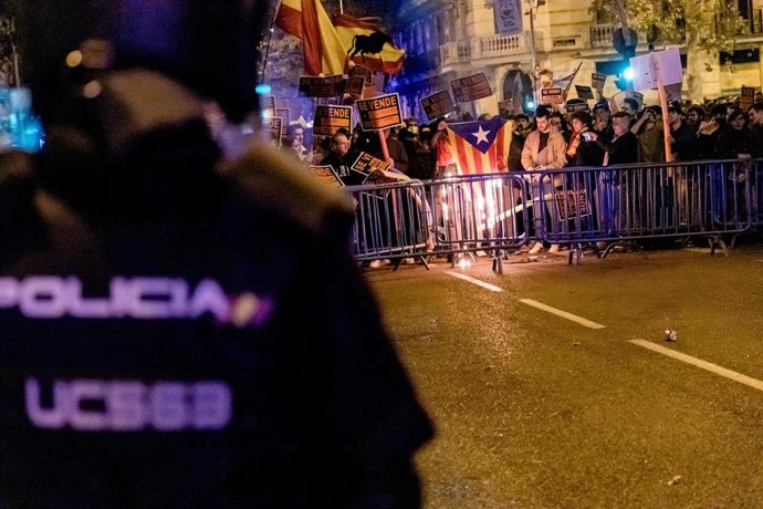 Decenas de manifestantes con carteles de 'se vende' queman una estelada, durante una manifestación contra la amnistía frente a la sede del PSOE en Ferraz, a 17 de noviembre de 2023, en Madrid (España). 