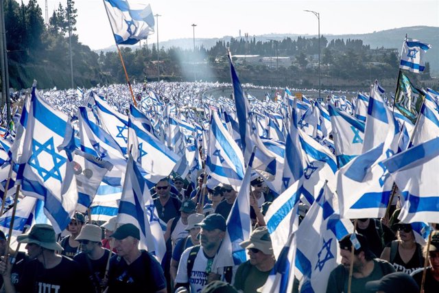 Archivo - July 22, 2023, Jerusalem, Israel: Protestors against the reform wave the Israeli flags as they climb the entrance road to Jerusalem during the demonstration. Tens of thousands of protestors against the reform wave the Israeli flag as they climb 