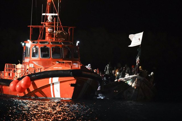 Decenas de personas en un cayuco son rescatadas a su llegada al muelle de La Restinga, a 4 de noviembre de 2023, en El Hierro, Islas Canarias (España). Salvamento Marítimo ha rescatado durante la madrugada de hoy un total de cuatro cayucos en aguas cercan