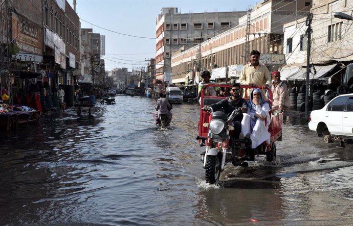 Archivo - 26 September 2023, Pakistan, Hyderabad: People drive over a flooded road caused by an overflowing sewer system after a heavy rains. Photo: -/PPI via ZUMA Press Wire/dpa