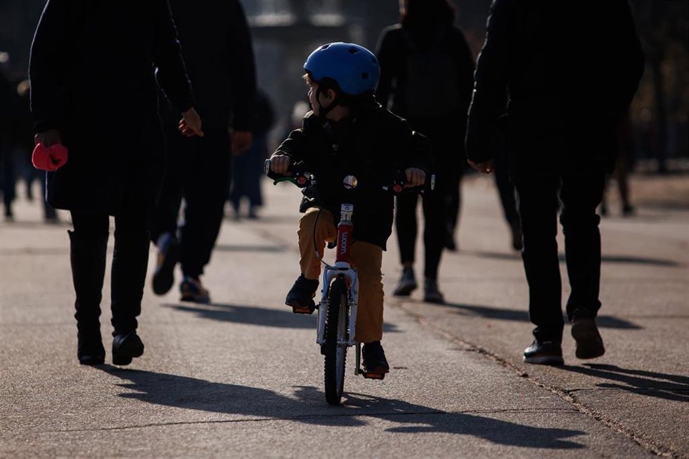 Archivo - Un niño pasea en su bicicleta en el parque del Retiro.