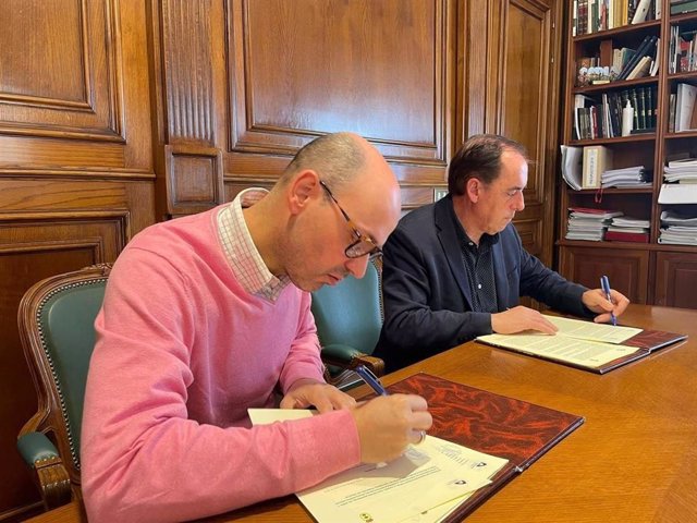 Juan Ramón Soria (izda) y Benito Serrano firman el convenio para rehabilitar el matadero de Vinuesa.