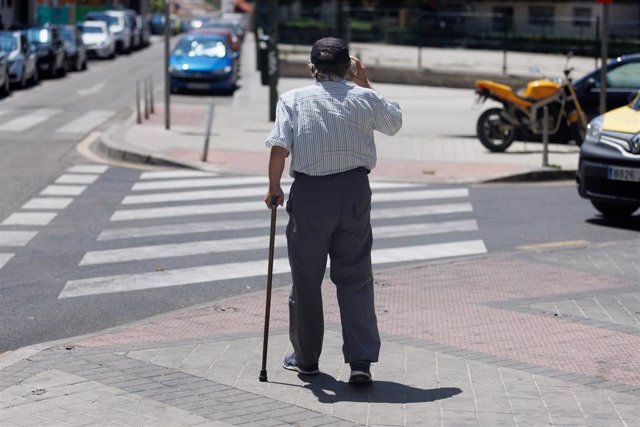 Archivo - Un hombre mayor pasea apoyándose en un bastón, a 24 de julio de 2023, en Madrid (España).