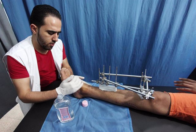 Archivo - Imagen de archivo de un miembro de Médicos Sin Fonteras (MSF) junto a un herido en Gaza. 