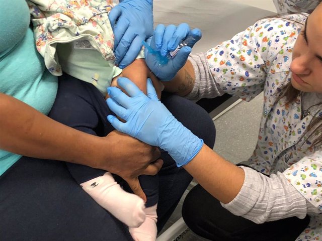 Una enfermera administra una vacuna a una menor.