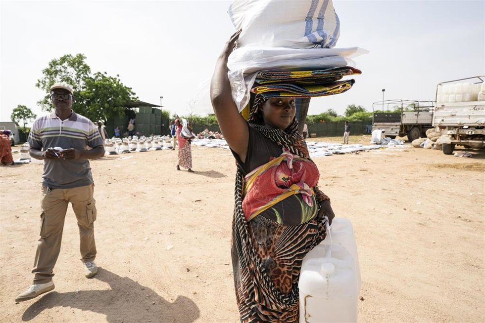 Archivo - Personas tras recoger ayuda en un campamento de desplazados internos cerca de Nyala, en Darfur Sur, Sudán