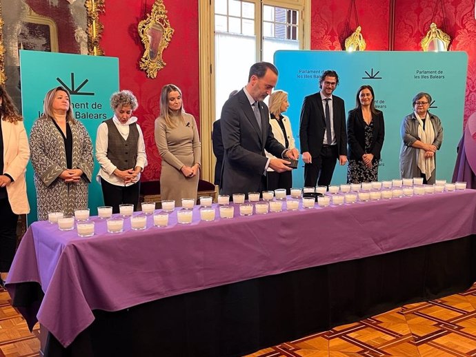 El presidente del Parlament, Gabriel Le Senne, enciende una vela por las víctimas de la violencia de género.
