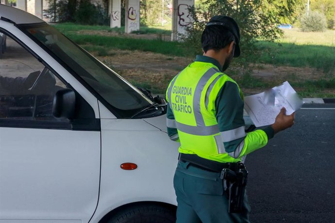 Archivo - Un agente de la Guardia Civil de Tráfico revisa la documentación de una furgoneta durante una campaña especial de la DGT.