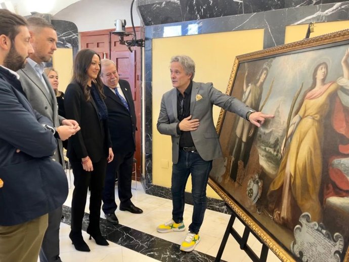 La consejera Carmen Conesa y el alcalde José Francisco García atienden a las explicaciones del comisario de la exposición sobre una de las obras que forman parte de la exposición