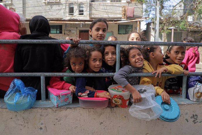 Un grupo de niños esperan la entrega de ayuda humanitaria en la ciudad de Rafá, situada en el sur de la Franja de Gaza, en la frontera con Egipto