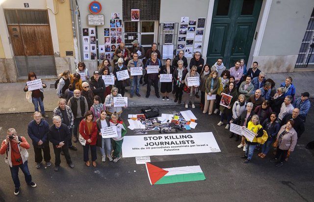 Diverses persones al costat d'una pancarta amb el lema: 'Stop killing journalists' durant una concentració de la Unió de Periodistes Valencians en defensa de la llibertat de premsa i el dret a la informació en la Franja de Gaza. 
