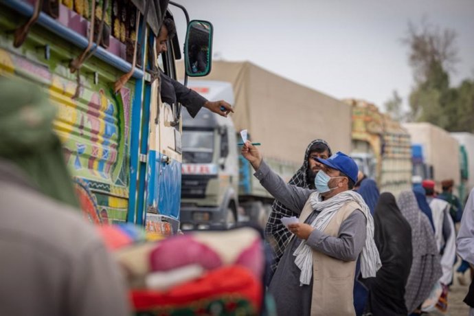 Personal de la OIM distrubuye tarjetas a los afganos que vuelven a su país desde Pakistán