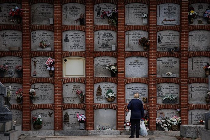 Una mujer delante de varios nichos en el cementerio de la Almudena, a 1 de noviembre de 2023, en Madrid (España).