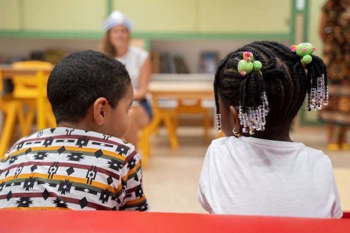 Archivo - Xiquets en un aula amb la seua professora (arxiu)