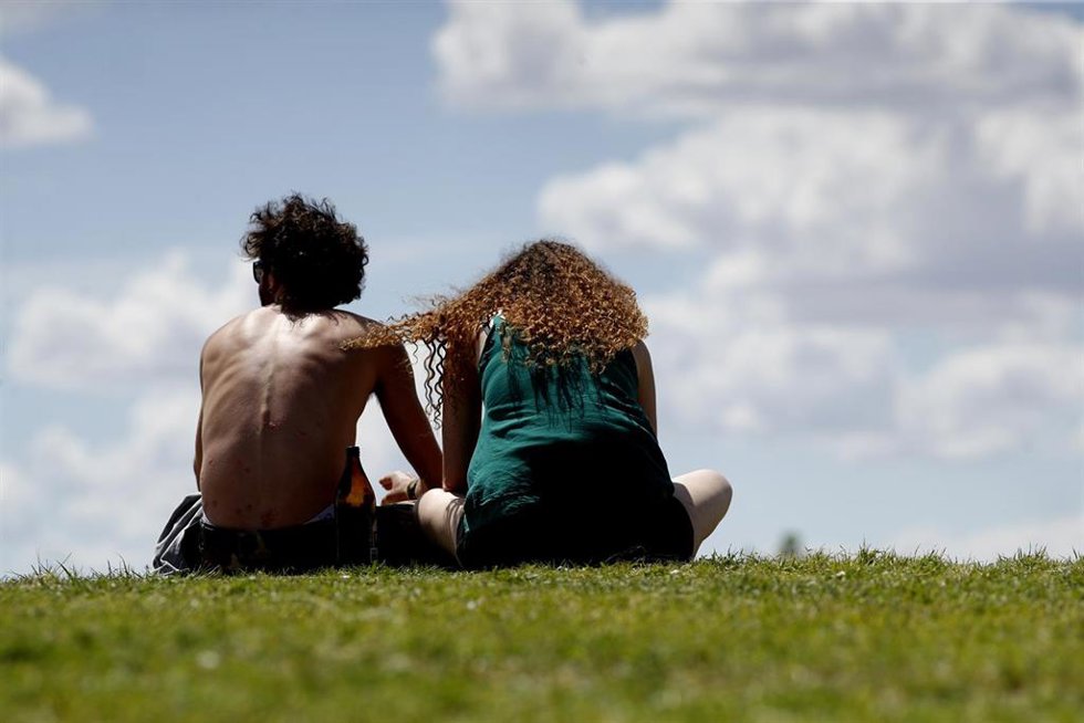 Archivo - Una pareja de jóvenes disfruta de un soleado día sentados en el césped 