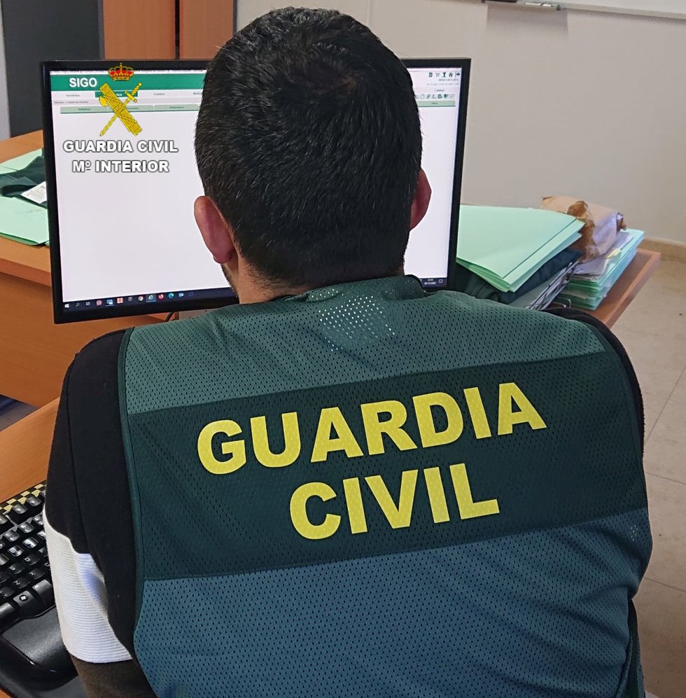 Archivo - Un agente de la Guardia Civil mira la pantalla de un ordenador