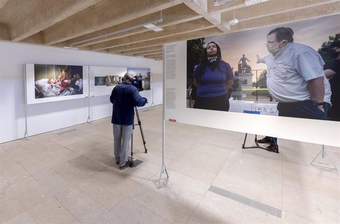 Archivo - Un hombre graba con una cámara de televisión una de las imágenes que componen la exposición World Press Photo 2021, en el Colegio Oficial de Arquitectos de Madrid (COAM), a 5 de noviembre de 2021, en Madrid (España). 