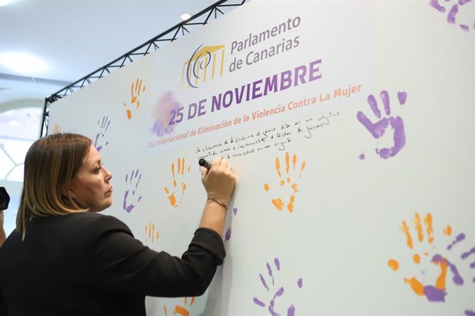 La presidenta del Parlamento de Canarias, Astrid Pérez, escribe el primer mensaje en un mural con motivo del Día Internacional por la Eliminación de la Violencia contra las Mujeres